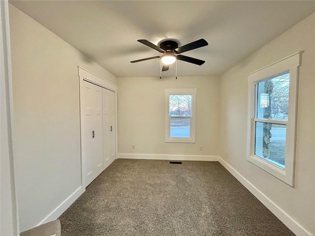 601 S Grand St, Salem, MO 65560 - unfurnished bedroom with dark carpet, baseboards, a ceiling fan, and a closet