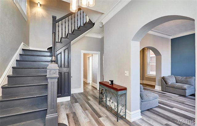 2922 S Compton Ave, Saint Louis, MO 63118 - stairway with wood finished floors, baseboards, arched walkways, and crown molding