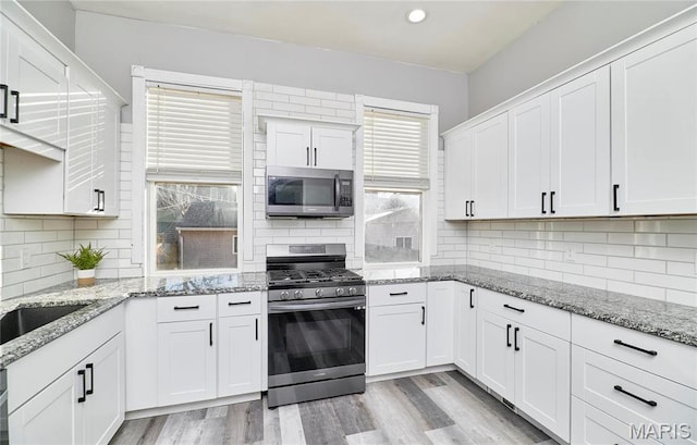 2922 S Compton Ave, Saint Louis, MO 63118 - kitchen featuring stainless steel appliances, backsplash, white cabinetry, and recessed lighting
