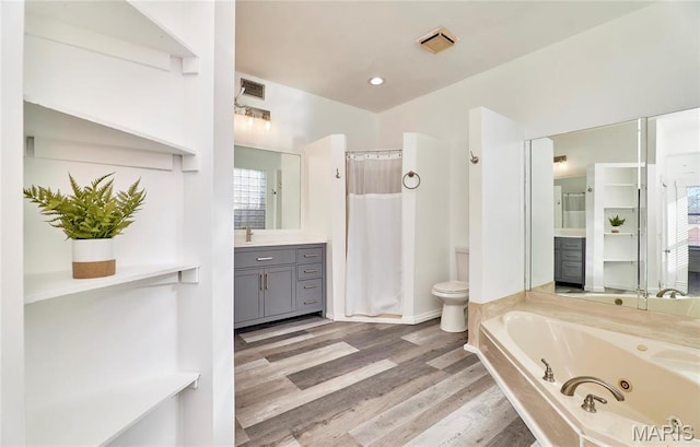 2922 S Compton Ave, Saint Louis, MO 63118 - bathroom with toilet, a tub with jets, vanity, wood finished floors, and a shower with shower curtain