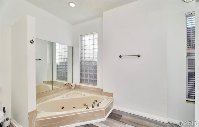 2922 S Compton Ave, Saint Louis, MO 63118 - bathroom with a tub with jets, wood finished floors, and baseboards
