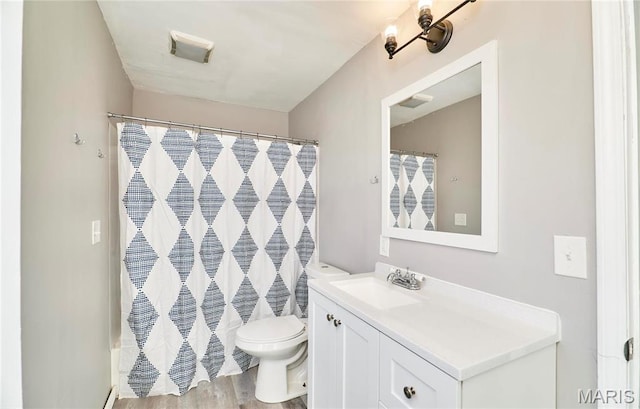 2922 S Compton Ave, Saint Louis, MO 63118 - bathroom with toilet, vanity, wood finished floors, and a shower with shower curtain