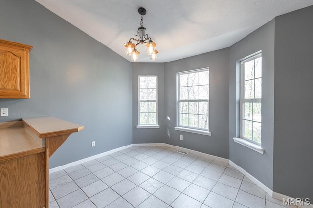 16855 Lemming Ln, Saint Robert, MO 65584 - unfurnished dining area featuring a chandelier, baseboards, light tile patterned floors, and vaulted ceiling