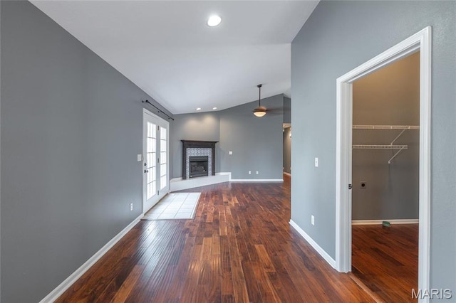 16855 Lemming Ln, Saint Robert, MO 65584 - unfurnished living room featuring hardwood / wood-style flooring, vaulted ceiling, a fireplace with raised hearth, baseboards, and recessed lighting