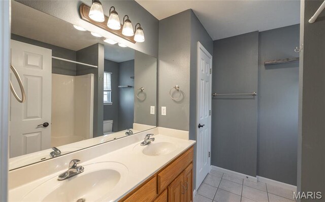 16855 Lemming Ln, Saint Robert, MO 65584 - bathroom featuring a shower, toilet, tile patterned floors, baseboards, and double vanity