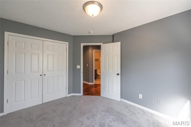 16855 Lemming Ln, Saint Robert, MO 65584 - unfurnished bedroom featuring baseboards, a closet, and dark colored carpet
