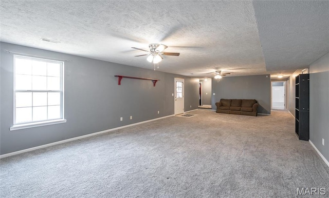 16855 Lemming Ln, Saint Robert, MO 65584 - unfurnished living room featuring ceiling fan, a textured ceiling, carpet flooring, and baseboards