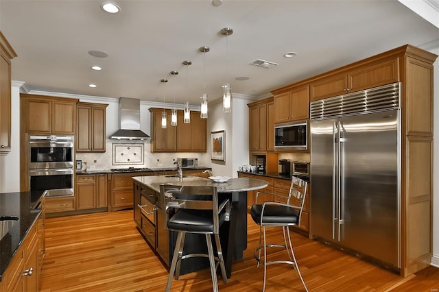 155 Carondelet Plz Unit 600, Saint Louis, MO 63105 - kitchen featuring built in appliances, wall chimney exhaust hood, brown cabinetry, tasteful backsplash, and crown molding
