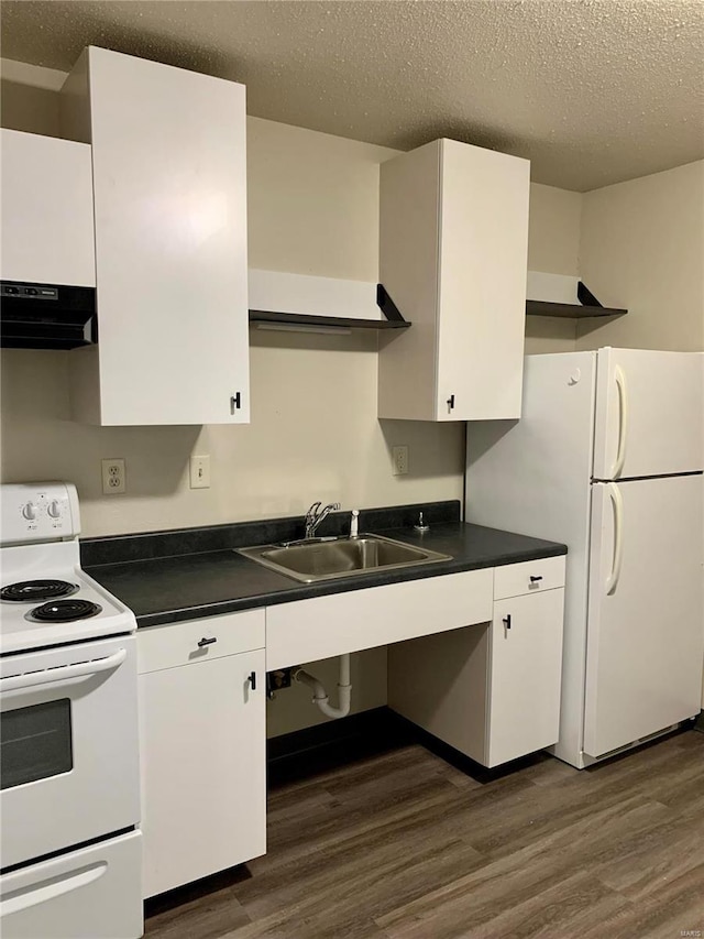 kitchen featuring white appliances, range hood, a sink, dark countertops, and a textured ceiling