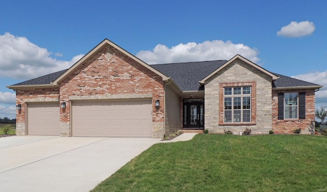 view of front of property featuring a garage, driveway, a front lawn, stone siding, and roof with shingles
