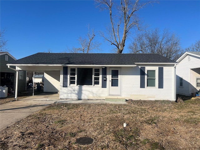 ranch-style home with driveway, roof with shingles, and a carport