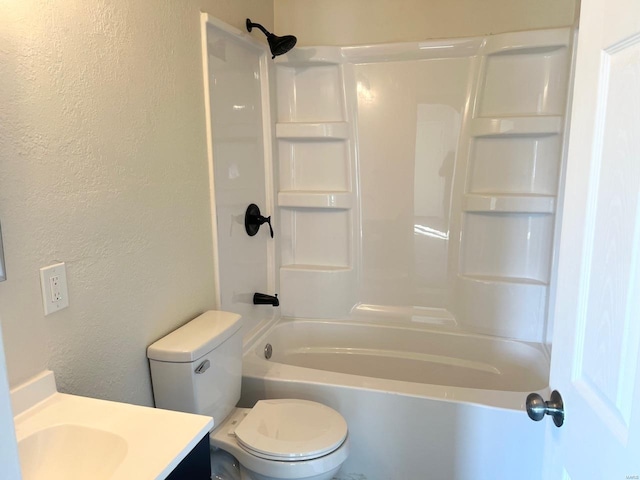 bathroom featuring a textured wall, vanity, toilet, and bathtub / shower combination