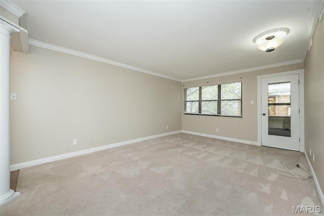 unfurnished room featuring ornate columns, light colored carpet, crown molding, and baseboards