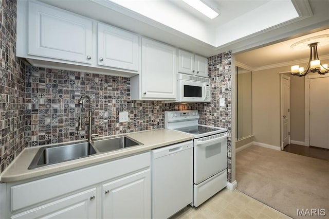 kitchen with white appliances, a sink, white cabinets, backsplash, and a chandelier