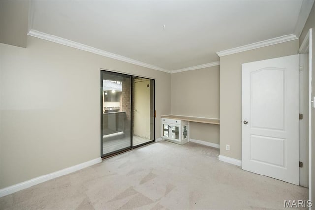 empty room featuring ornamental molding, baseboards, and carpet flooring