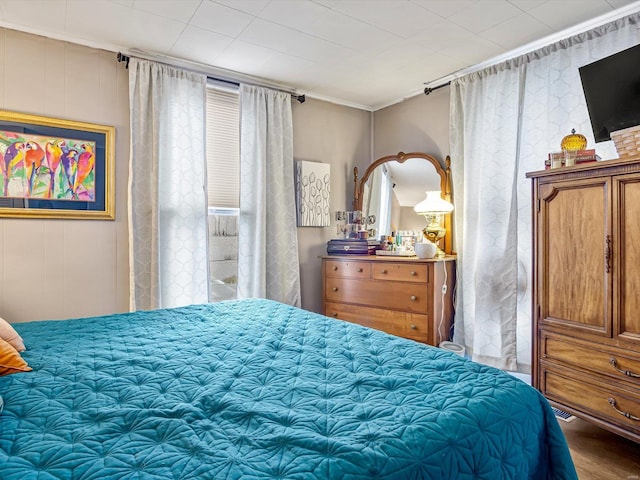 bedroom featuring crown molding and wood finished floors