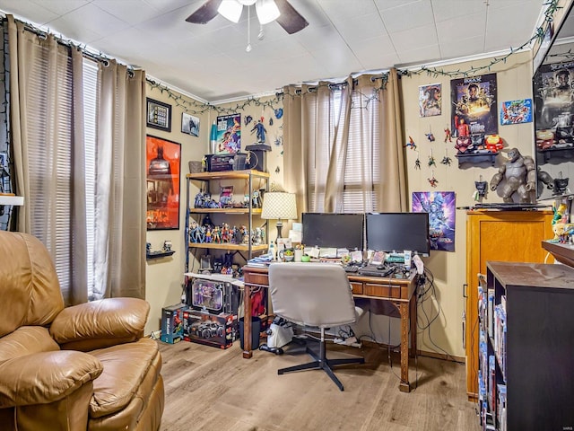 office with plenty of natural light, wood finished floors, and a ceiling fan