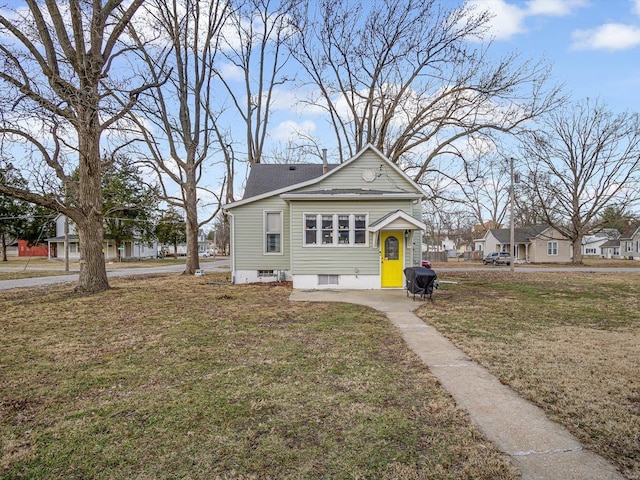 rear view of property featuring a yard and a shingled roof