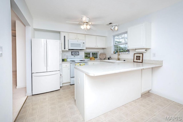 11741 Casa Grande Dr Unit G, Creve Coeur Township, MO 63146 - kitchen featuring white appliances, a sink, a peninsula, light countertops, and white cabinetry