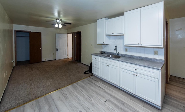 670 S Main St, Saint Clair, MO 63077 - kitchen with a sink, a ceiling fan, white cabinetry, light wood-style floors, and backsplash