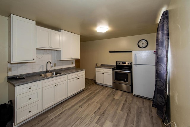 670 S Main St, Saint Clair, MO 63077 - kitchen featuring stainless steel range with electric cooktop, freestanding refrigerator, a sink, dark countertops, and light wood finished floors