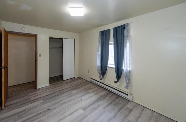 670 S Main St, Saint Clair, MO 63077 - unfurnished bedroom featuring a baseboard heating unit, light wood-style floors, a closet, and baseboards