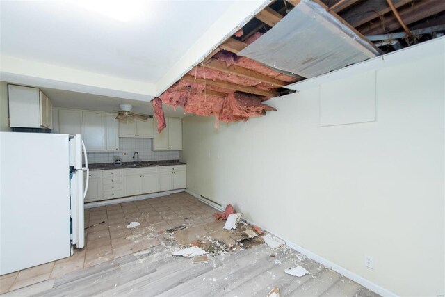 670 S Main St, Saint Clair, MO 63077 - kitchen featuring freestanding refrigerator, a sink, decorative backsplash, dark countertops, and a baseboard heating unit