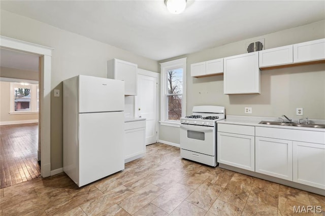 3142 Thelma Ave, Saint Louis, MO 63121 - kitchen featuring white appliances, a sink, white cabinetry, light countertops, and baseboards