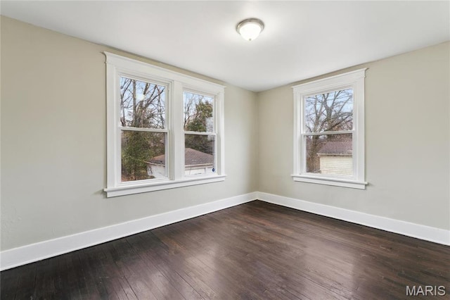 3142 Thelma Ave, Saint Louis, MO 63121 - empty room featuring baseboards, dark wood-style floors, and healthy amount of natural light