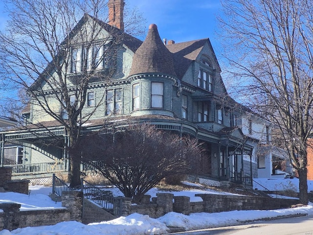 view of front facade featuring a porch and a chimney