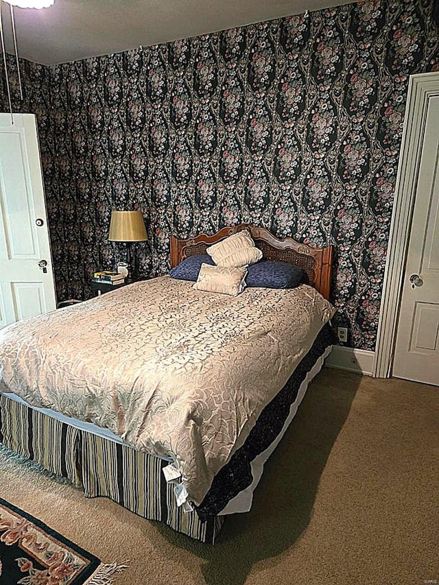 carpeted bedroom with wallpapered walls and baseboards
