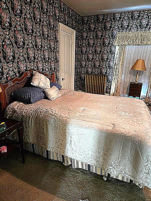 bedroom with wallpapered walls and carpet flooring