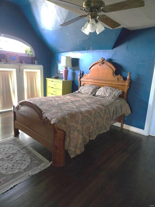 bedroom with lofted ceiling, wood finished floors, baseboards, and ceiling fan