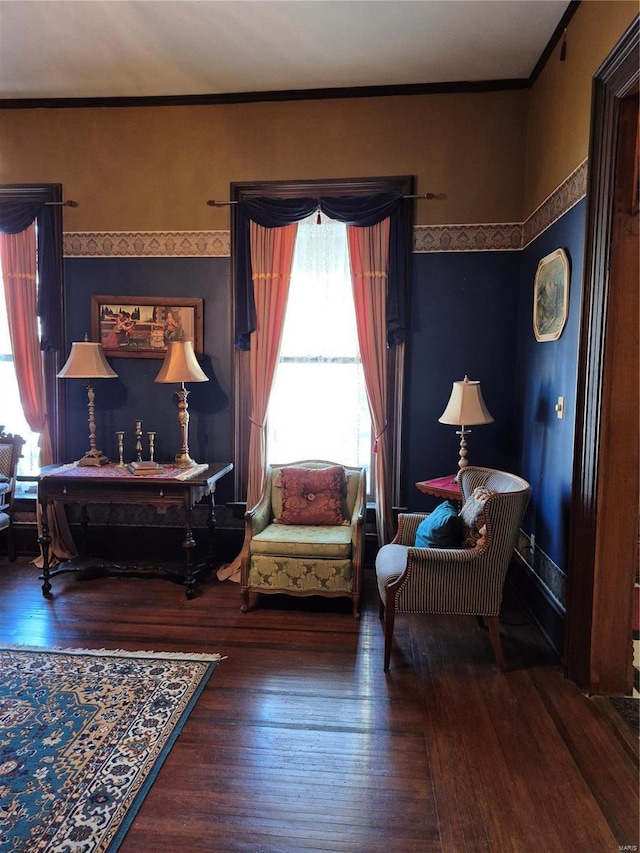 living area featuring crown molding, wood finished floors, and wallpapered walls