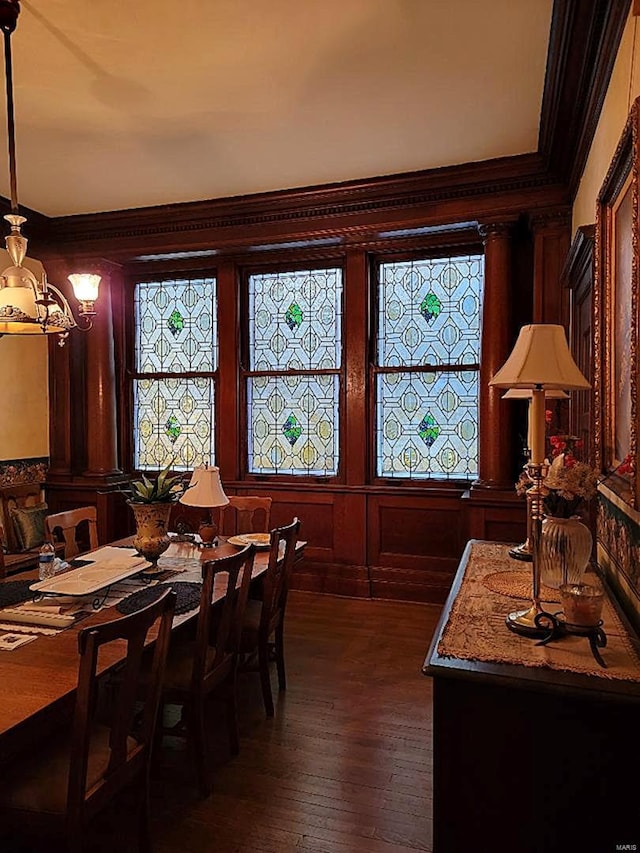dining space featuring ornamental molding, a chandelier, and dark wood-style floors