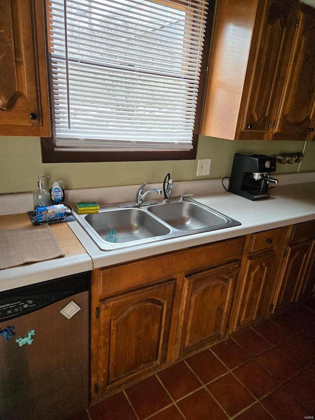 kitchen with a sink, dishwasher, light countertops, and brown cabinetry
