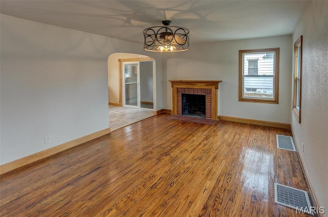 134 N 82nd St, Belleville, IL 62223 - unfurnished living room featuring arched walkways, wood finished floors, a fireplace, baseboards, and a ceiling fan