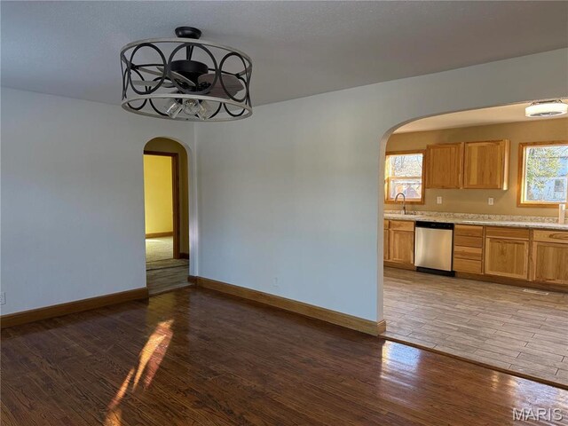 134 N 82nd St, Belleville, IL 62223 - kitchen featuring arched walkways, stainless steel dishwasher, light wood finished floors, and light countertops
