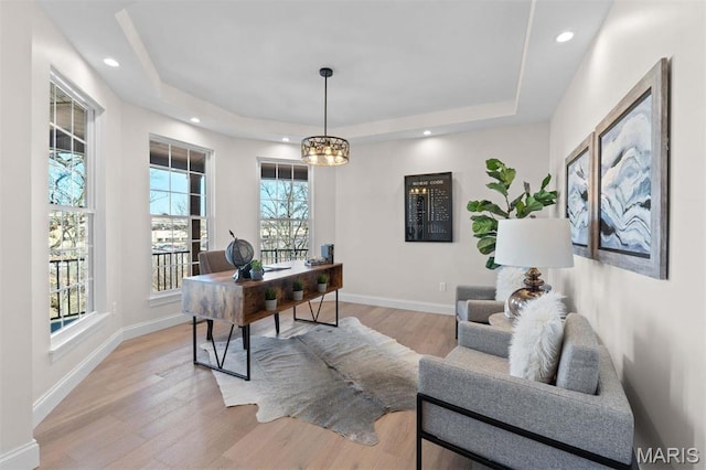 office with a tray ceiling, light wood finished floors, baseboards, and recessed lighting