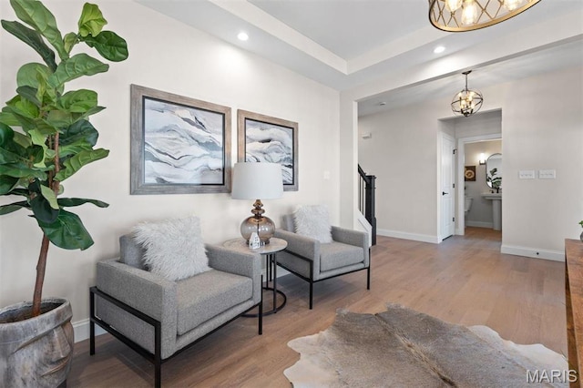 sitting room with a chandelier, wood finished floors, baseboards, and recessed lighting