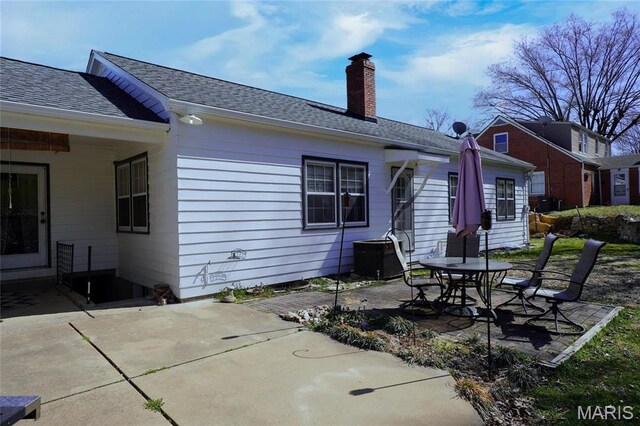 1014 Jefferson St, Hermann, MO 65041 - back of property featuring a patio area, a chimney, and roof with shingles