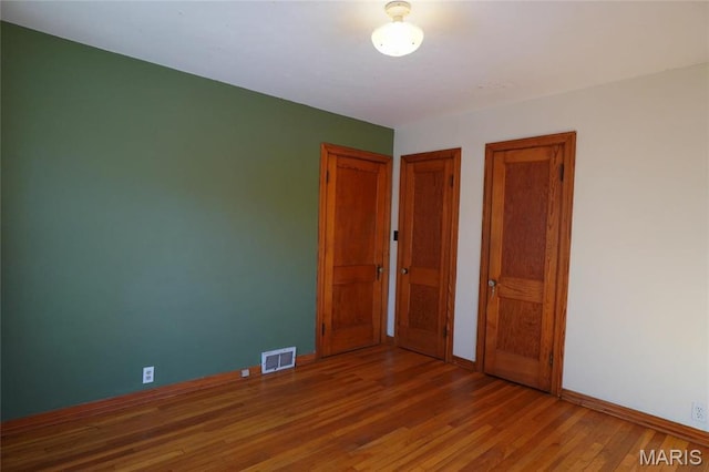 1014 Jefferson St, Hermann, MO 65041 - unfurnished bedroom with multiple closets and wood finished floors