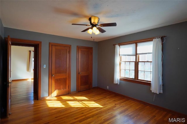 1014 Jefferson St, Hermann, MO 65041 - unfurnished bedroom featuring light wood-style flooring, multiple closets, and a ceiling fan