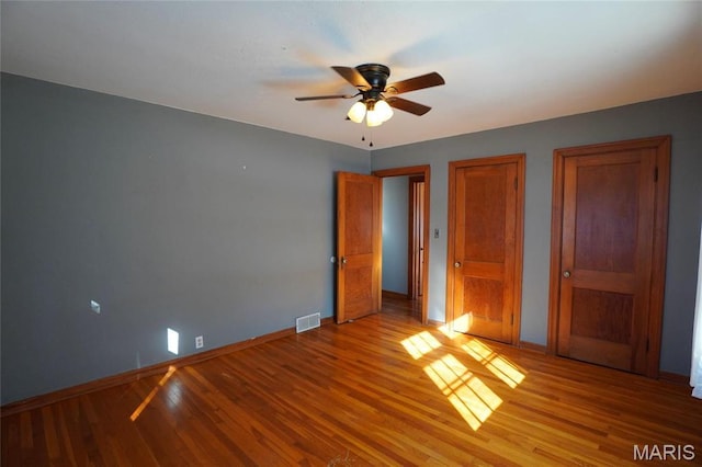 1014 Jefferson St, Hermann, MO 65041 - unfurnished bedroom with two closets, light wood-type flooring, and a ceiling fan