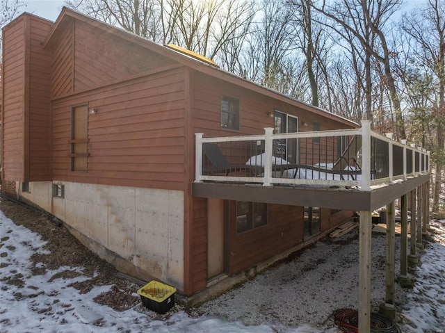 view of snowy exterior featuring a deck