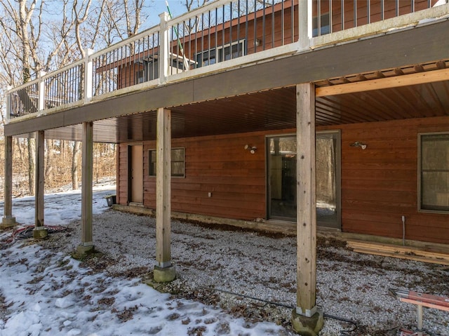 snow covered patio with a deck