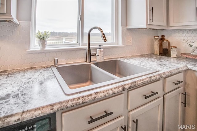 kitchen featuring a sink, light countertops, and decorative backsplash