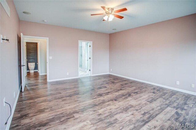 spare room with a ceiling fan, wood finished floors, and baseboards