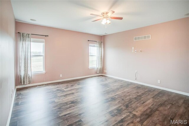 empty room with ceiling fan, dark wood-style flooring, and baseboards