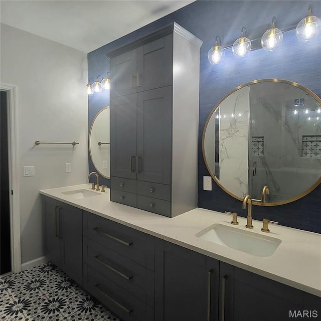 full bath featuring a marble finish shower, double vanity, and baseboards